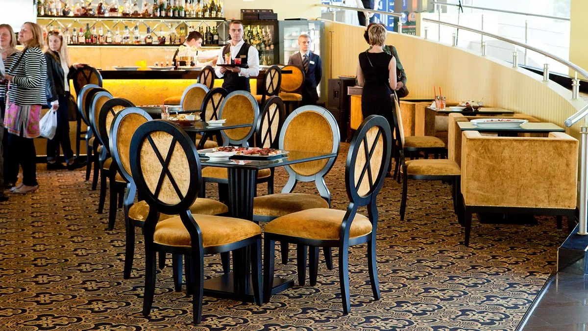 Sedia da ristorante contemporanea Anello, con rivestimento in velluto color oro e struttura in legno nero. Presso il Baltic Beach Hotel di Jurmala, Lettonia