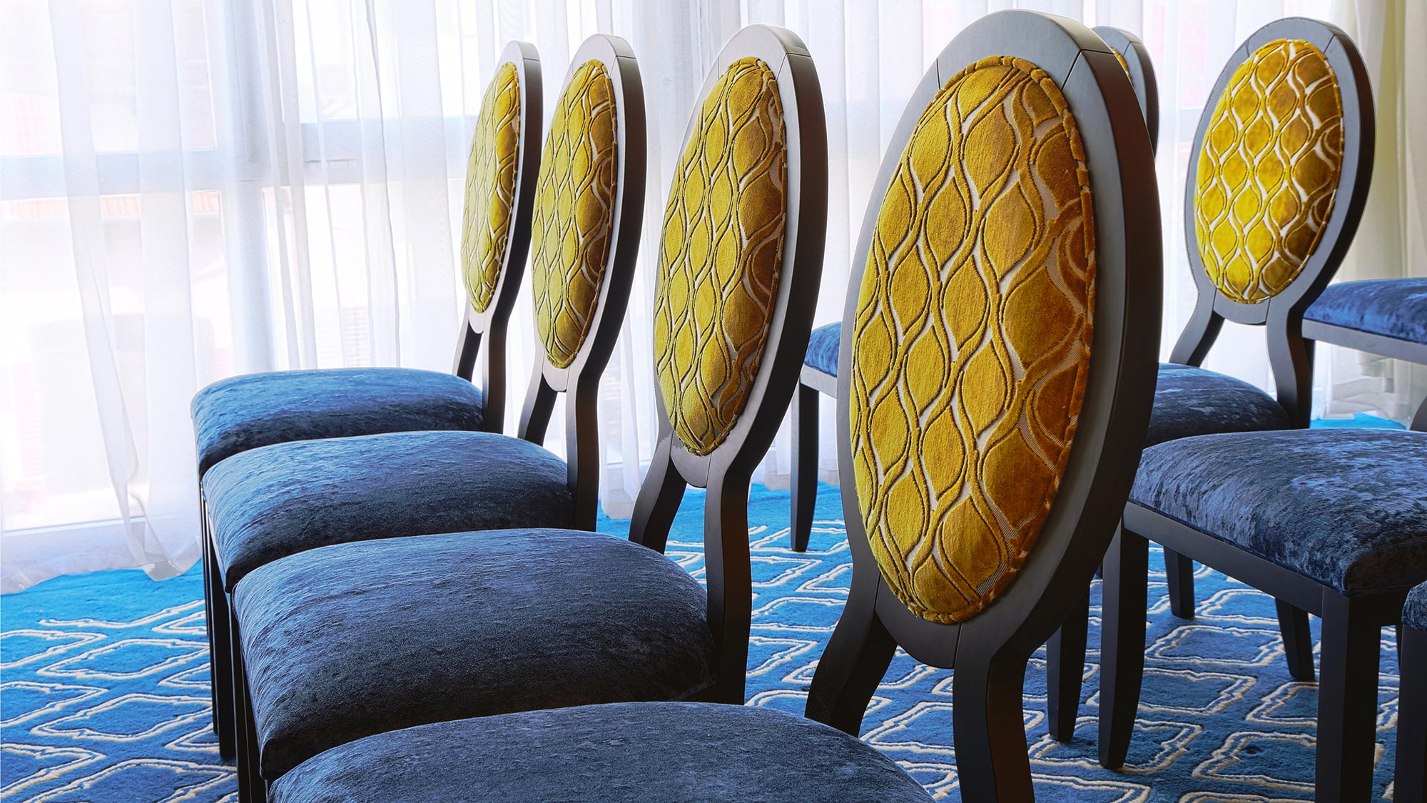 Close picture showing the details of a few Anello chairs upholstered in a two tone blue and yellow velvet. Hi quality contemporary dining chairs, 100% made in Italy